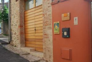 uma porta de garagem de madeira com um parquímetro num edifício em La Grange aux hirondelles em Laroque-des-Albères
