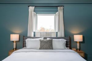 a blue bedroom with a large bed with two lamps at The August House in Windsor