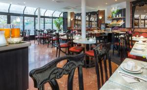 un comedor con mesas y sillas en un restaurante en Hôtel Opera Lafayette en París