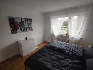 Schlafzimmer mit einem Bett und einem Fenster in der Unterkunft Vogelnest - Wohlfühlen im Grünen in Karlsruhe