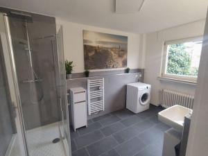 a bathroom with a shower and a washing machine at Vogelnest - Wohlfühlen im Grünen in Karlsruhe