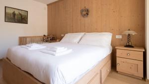 a bedroom with a large bed with two towels on it at Italianway - Milano 26 in Bormio