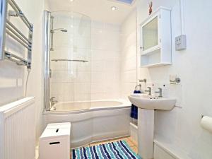 a white bathroom with a sink and a bath tub at Barnacles in Alnwick
