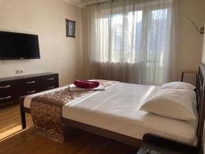 um quarto com uma cama grande e uma janela em Doba In Ua Peremoga Apartments em Dnipro