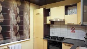 a kitchen with wooden cabinets and a stove top oven at Doba In Ua Peremoga Apartments in Dnipro