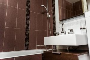 La salle de bains est pourvue d'un lavabo et d'une baignoire. dans l'établissement Doba In Ua Peremoga Apartments, à Dnipro