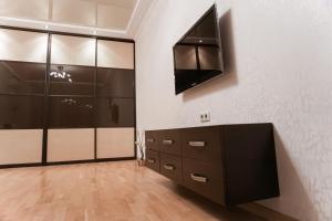 a dressing room with lockers and a tv on the wall at Doba In Ua Peremoga Apartments in Dnipro