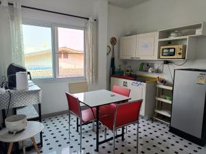 Merit Courtyard Suvarnabhumi House في لاكريبنغ لاد: مطبخ مع طاولة وكراسي وثلاجة