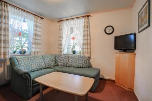 a living room with a couch and a table and a tv at Stössels Hotel & Restaurant in Altenmedingen