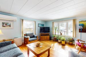 a living room with a couch and a tv at Pineapple Cottage By The Sea in Ogunquit