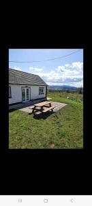 a picnic table in the grass in front of a building at Holywell cottage 