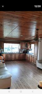 a large living room with wooden floors and a kitchen at Holywell cottage 