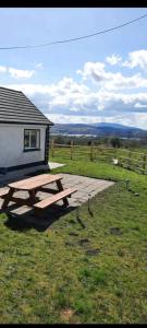 a picnic table in the grass next to a building at Holywell cottage 
