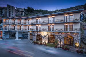 un gran edificio blanco con ventanas y una calle en Arahova Inn Hotel, en Arachova