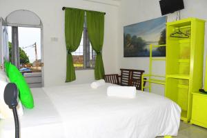 a bedroom with a white bed and a yellow shelf at Rampart View Guesthouse in Galle