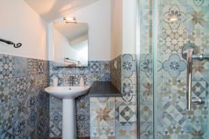 La salle de bains est pourvue d'un lavabo et d'une douche. dans l'établissement Etnalodge, à Piedimonte Etneo