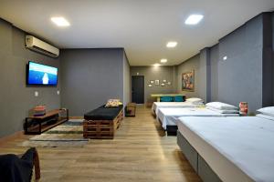 Habitación hospitalaria con muchas camas y TV de pantalla plana. en HOTEL SENADoR, en Ribeirão Preto