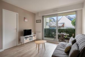 a living room with a couch and a television at Coquet appartement a 300 m du port du Pouliguen in Le Pouliguen