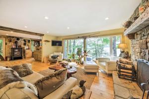 a living room with couches and a stone fireplace at Beautiful Embden Pond Cabin with Dock and Kayaks! in Embden