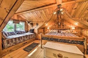 a log cabin bedroom with two beds and a chandelier at Beautiful Embden Pond Cabin with Dock and Kayaks! in Embden