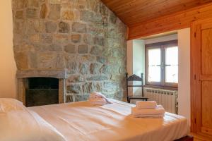 - une chambre avec une cheminée en pierre et un lit avec 2 serviettes dans l'établissement Il Salice by Wonderful Italy, à Bellagio