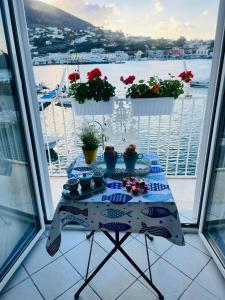 una mesa con comida y flores en el balcón en Riva Destra Suite apartament, en Isquia