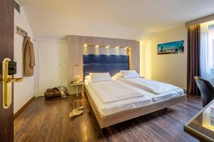 a bedroom with a large bed with a blue headboard at Hotel Alexander Zurich Old Town in Zurich