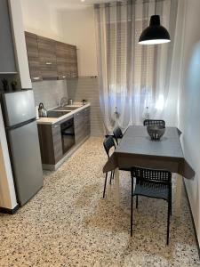 uma cozinha com uma mesa e cadeiras e um frigorífico em La casa di Nettuno em La Spezia