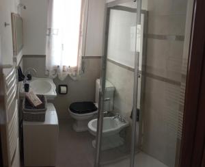 uma casa de banho com um WC e uma cabina de duche em vidro. em La casa di Nettuno em La Spezia
