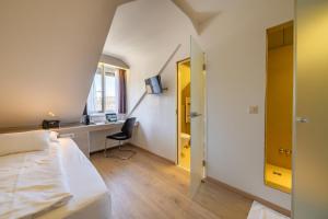 a bedroom with a bed and a desk and a window at Hotel Alexander Zurich Old Town in Zurich