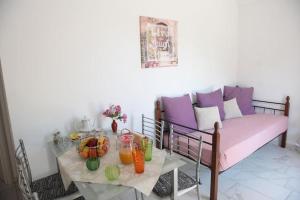 a living room with a couch and a table with fruit at Filoxenia Apartments Corfu Rose in Alepou