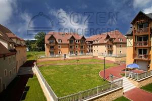 a group of buildings with a grassy field in front at F50 Ferme de Deauville 1 CH rez-de-jardin avec escalier in Saint-Arnoult
