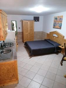 a bedroom with a bed and a kitchen with a stove at Appartamenti Frassanito in Conca Specchiulla