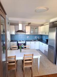 a kitchen with a white table and chairs and a refrigerator at Kiki's Place in Nikiti