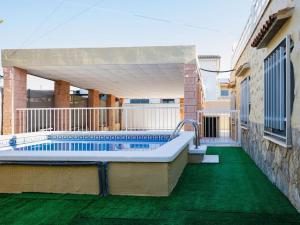 una piscina al lado de un edificio en Casa con piscina a 5 min de la playa, en Burriana