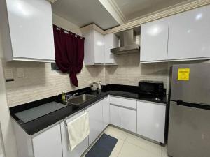 a small kitchen with white cabinets and a sink at Kandi big 1 BR, king bed, free housekeeping, Wi-Fi in Angeles
