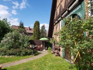ein Garten außerhalb eines Gebäudes mit einem Regenschirm in der Unterkunft Ferienhof-Jameln-Lüneburger-Heide in Jameln