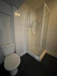 a bathroom with a white toilet and a shower at Stay at 25 in Blackpool