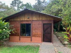 un pequeño cobertizo de madera con una puerta grande en Cataratas Bijagua Lodge, incluye tour autoguiado Bijagua Waterfalls Hike, en Bijagua