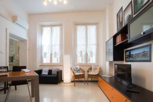 sala de estar con TV, sofá y mesa en Il Borgo appartamento Clelia, en Parma