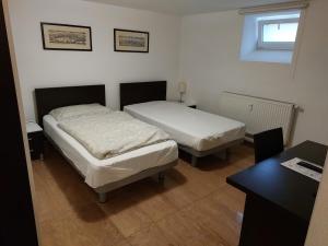 1 dormitorio con 2 camas, escritorio y mesa en Levidom Residence Rooms, en Levice