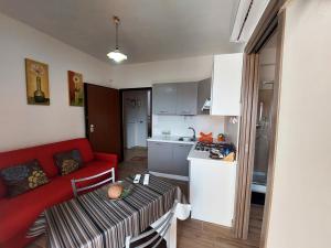 un soggiorno con divano rosso e una cucina di Katia's Home a Scalea