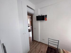 Habitación con TV en la pared y silla en Katia's Home, en Scalea
