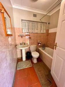Farm stay at Rosemary Cottage on Haldon Estate في بلومفونتين: حمام مع مرحاض ومغسلة وحوض استحمام