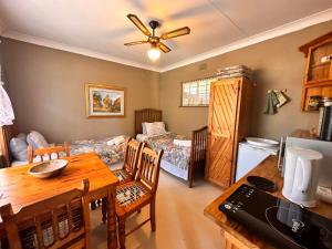 a kitchen and dining room with a table and a room with a bed at Farm stay at Rosemary Cottage on Haldon Estate in Bloemfontein