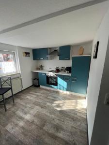 a kitchen with blue cabinets and a table and a chair at Perle im Zentrum in Eschwege