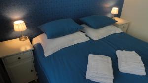 a blue bed with two pillows and towels on it at Bickersbed in Amsterdam