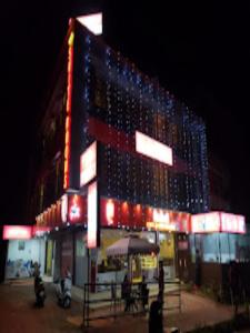 a large building with lights on it at night at Redbell Suites Manjeri in Manjeri
