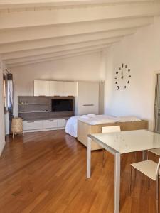 ein Schlafzimmer mit einem Bett und einem Tisch in einem Zimmer in der Unterkunft Vittoria al Lago in Desenzano del Garda