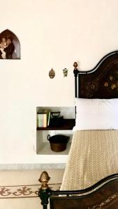 Schlafzimmer mit einem Bett mit einem Kopfteil aus Holz in der Unterkunft VaGiu' Dimora Storica in Tricase